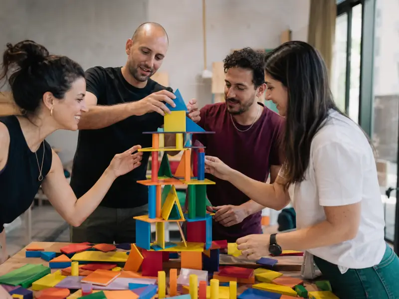 חברי צוות משתפים פעולה במשימת יצירה ומשחק צבעונית