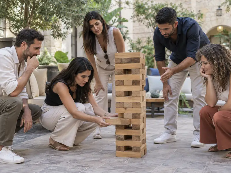 עובדים משתפים פעולה במשחק קוביות עץ בחצר מלון