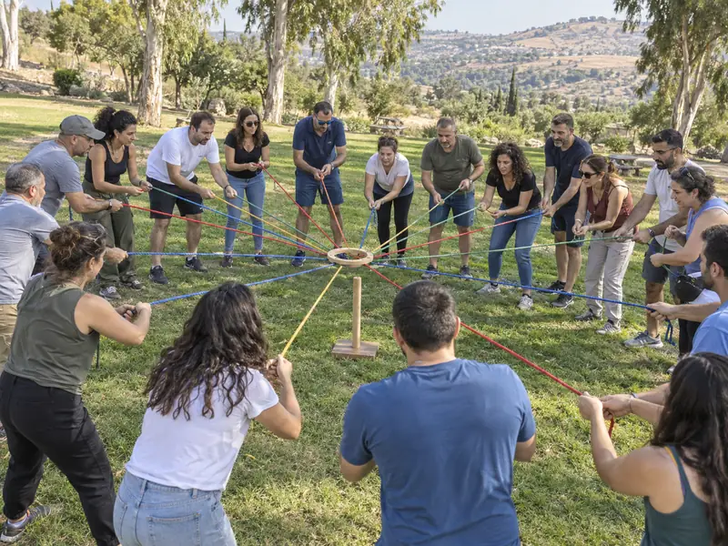 קבוצה גדולה משתפת פעולה באתגר חבלים קבוצתי